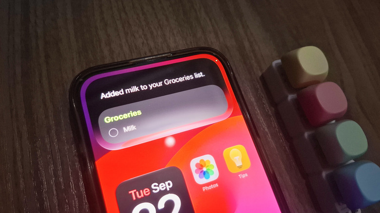 iPhone showing Siri AI adding milk to groceries list
