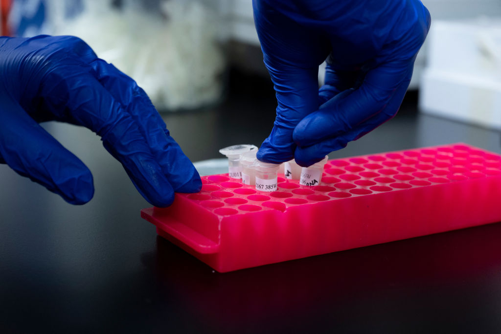 A person puts DNA and RNA vials into a container.