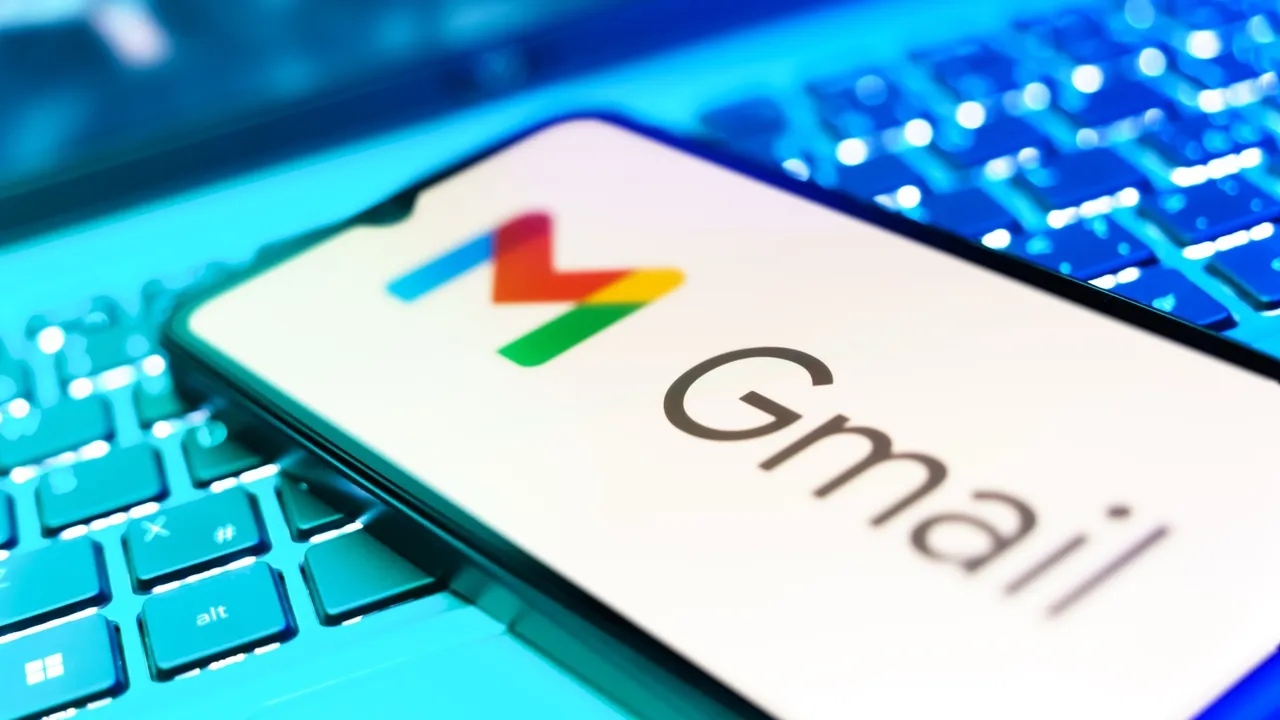 A smartphone with the Gmail logo on it resting on top of a computer keyboard.
