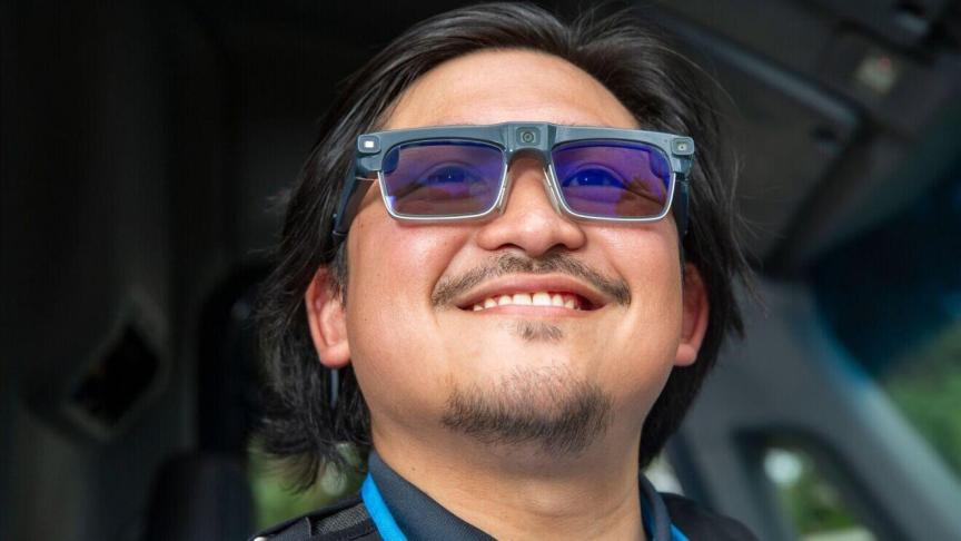 A man wears AI glasses and smiles.
