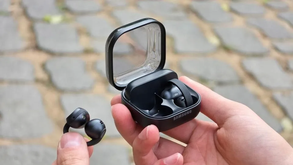 دستی که کیس شارژ باز هندزفری Galaxy Buds On سامسونگ را نگه داشته و دست دیگر یکی از ایربادهای کلیپسی را نشان میدهد
